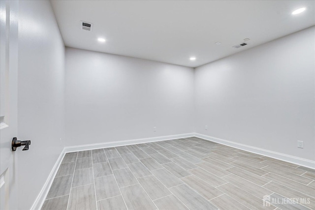 empty room featuring visible vents, recessed lighting, baseboards, and wood tiled floor