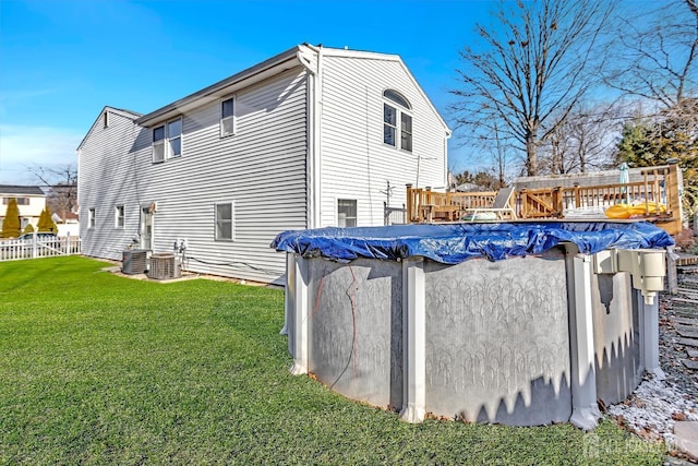 view of home's exterior featuring central air condition unit, a yard, and a covered pool