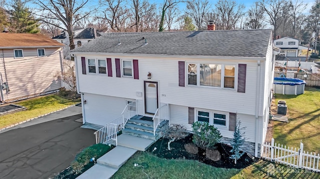 view of front of home featuring central AC and a covered pool