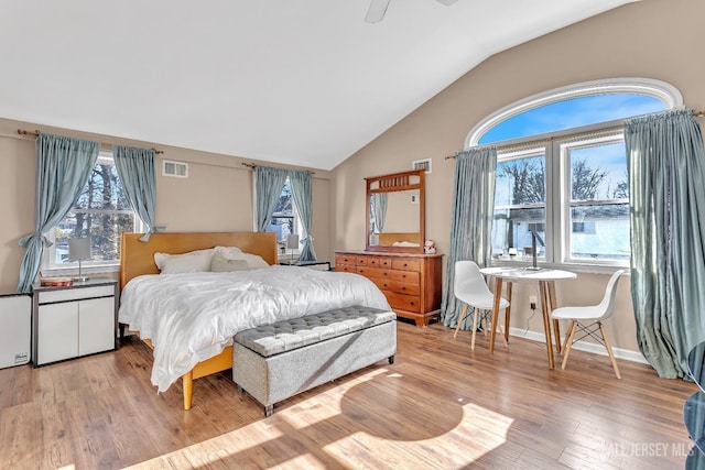 bedroom with ceiling fan, vaulted ceiling, multiple windows, and light hardwood / wood-style flooring