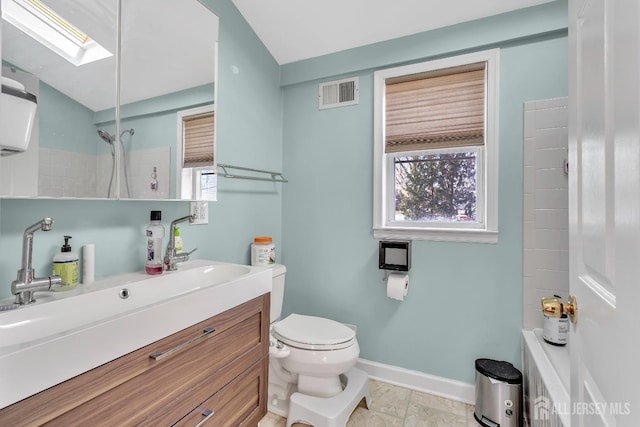 bathroom with a skylight, vanity, and toilet