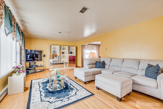 living room with hardwood / wood-style flooring and baseboard heating