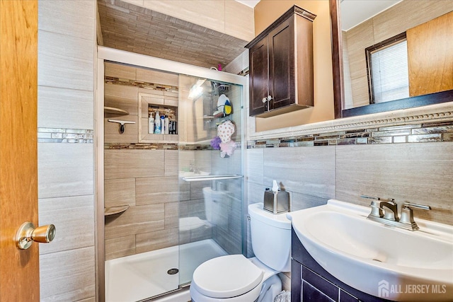 bathroom with vanity, toilet, an enclosed shower, and tile walls