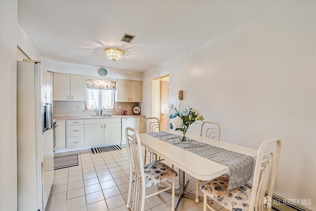 kitchen featuring white cabinetry, sink, white appliances, and light tile patterned flooring