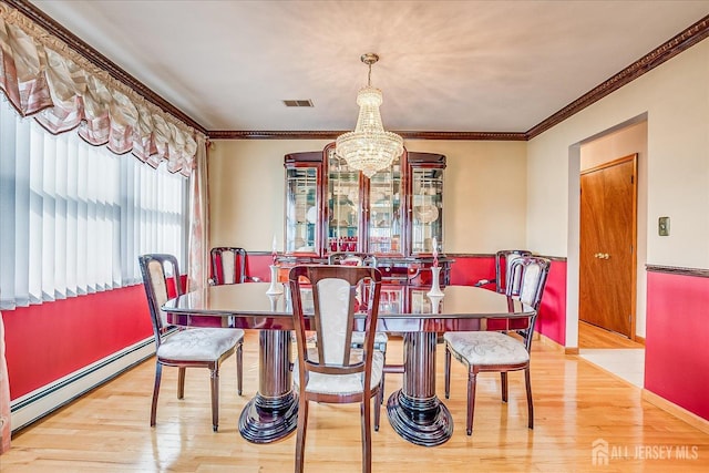 dining area with an inviting chandelier, crown molding, a baseboard radiator, and light hardwood / wood-style floors