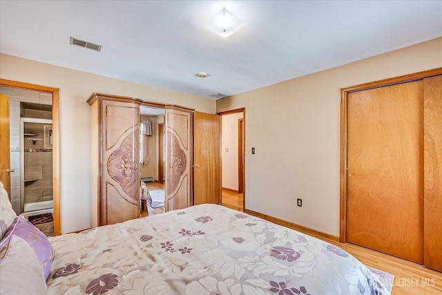 bedroom featuring light wood finished floors, visible vents, and baseboards