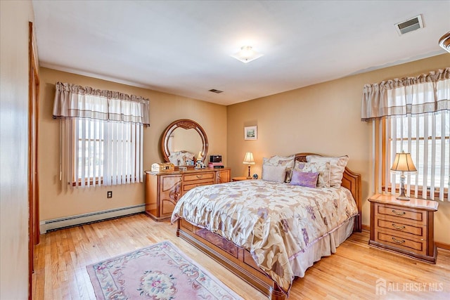 bedroom with a baseboard radiator and light hardwood / wood-style flooring