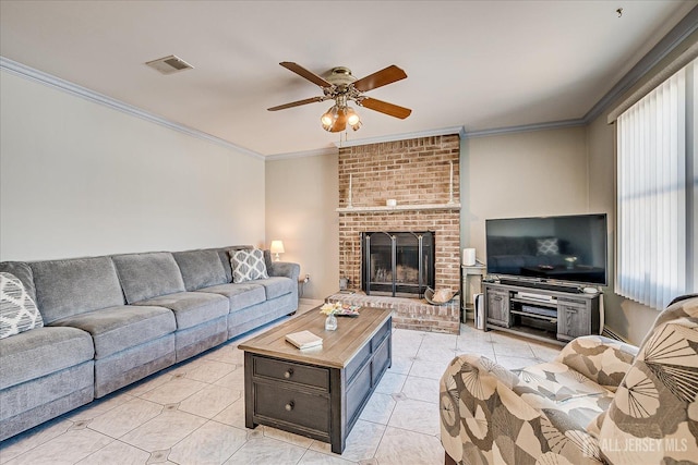 living room featuring ceiling fan, ornamental molding, a fireplace, and light tile patterned floors