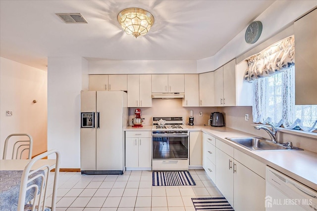 kitchen featuring sink, white appliances, and light tile patterned floors