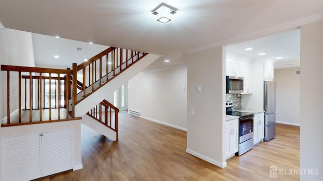 staircase with a baseboard heating unit, ornamental molding, and hardwood / wood-style flooring