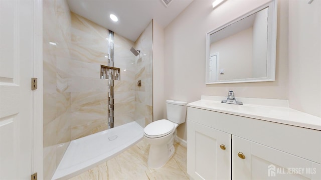 bathroom featuring tiled shower, vanity, and toilet