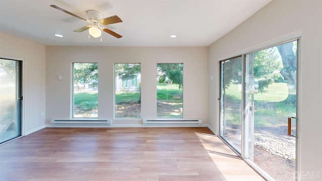 doorway to outside featuring a baseboard heating unit, ceiling fan, and light hardwood / wood-style flooring