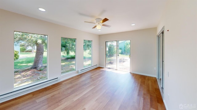 spare room featuring light hardwood / wood-style floors, a baseboard heating unit, and ceiling fan