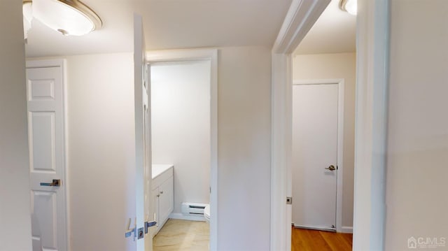 bathroom with toilet, vanity, baseboard heating, and hardwood / wood-style flooring