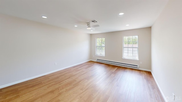 unfurnished room with ceiling fan, a baseboard heating unit, and light hardwood / wood-style floors