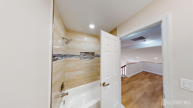 bathroom with wood-type flooring and tiled shower / bath combo