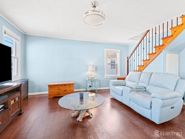 living room featuring dark wood-style floors, stairway, crown molding, and baseboards