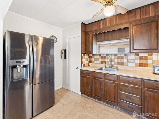 kitchen featuring light countertops, a ceiling fan, a sink, and stainless steel fridge with ice dispenser
