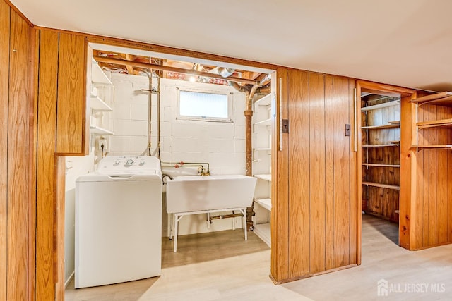 laundry room featuring laundry area, light wood finished floors, a sink, and washer / dryer