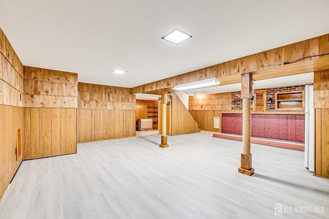 finished basement with wood walls and light wood-style floors