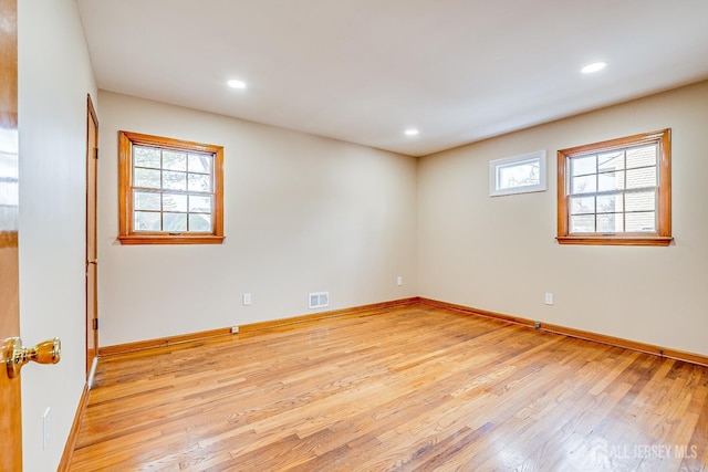 spare room featuring light wood-style floors, a wealth of natural light, and recessed lighting