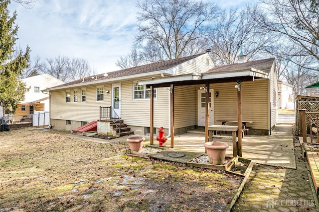 back of house featuring entry steps and fence