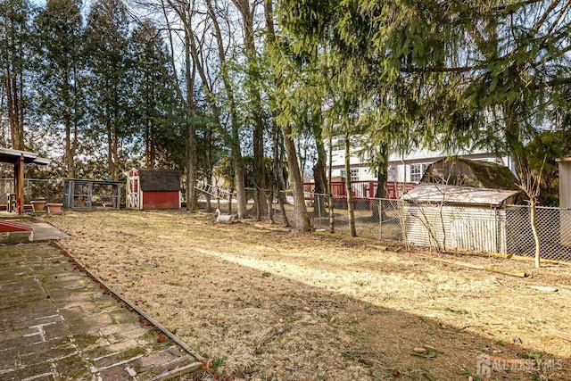 view of yard featuring a storage unit, fence, and an outbuilding