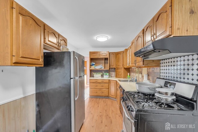 kitchen with sink, stainless steel appliances, and light wood-type flooring