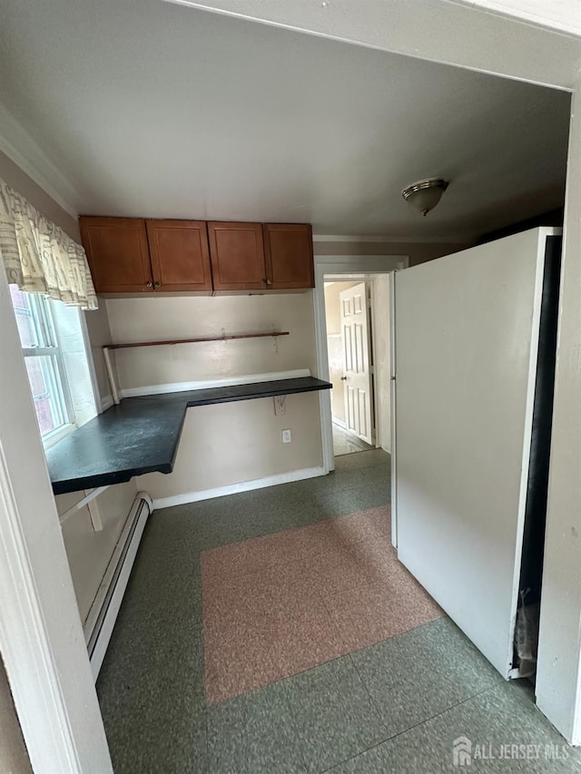 146 Seaman St, New Brunswick, NJ 08901 - kitchen with a baseboard heating unit, tile patterned floors, brown cabinetry, freestanding refrigerator, and a peninsula