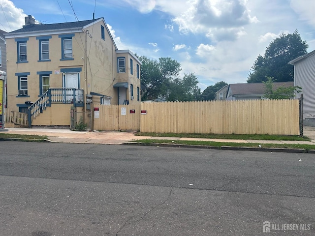 146 Seaman St, New Brunswick, NJ 08901 - view of front of home featuring a fenced front yard, stucco siding, a chimney, and a gate