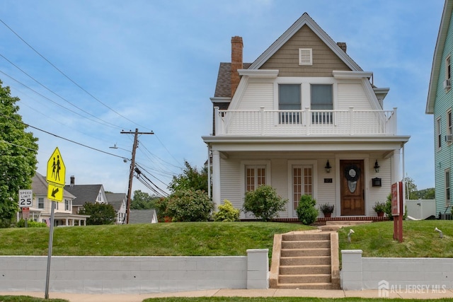 173 N Main St, Milltown, NJ 08850 - view of front of home featuring a balcony, a chimney, a porch, and a front lawn
