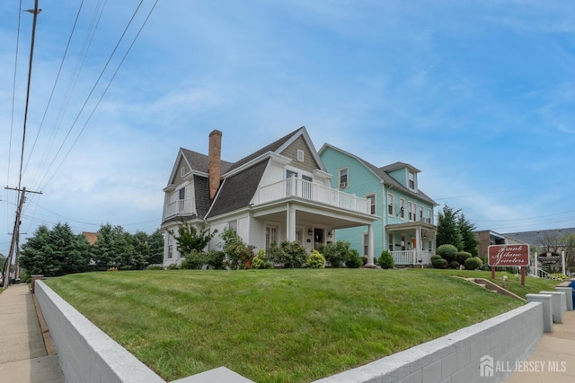 173 N Main St, Milltown, NJ 08850 - view of side of home with a balcony, a chimney, a lawn, and roof with shingles