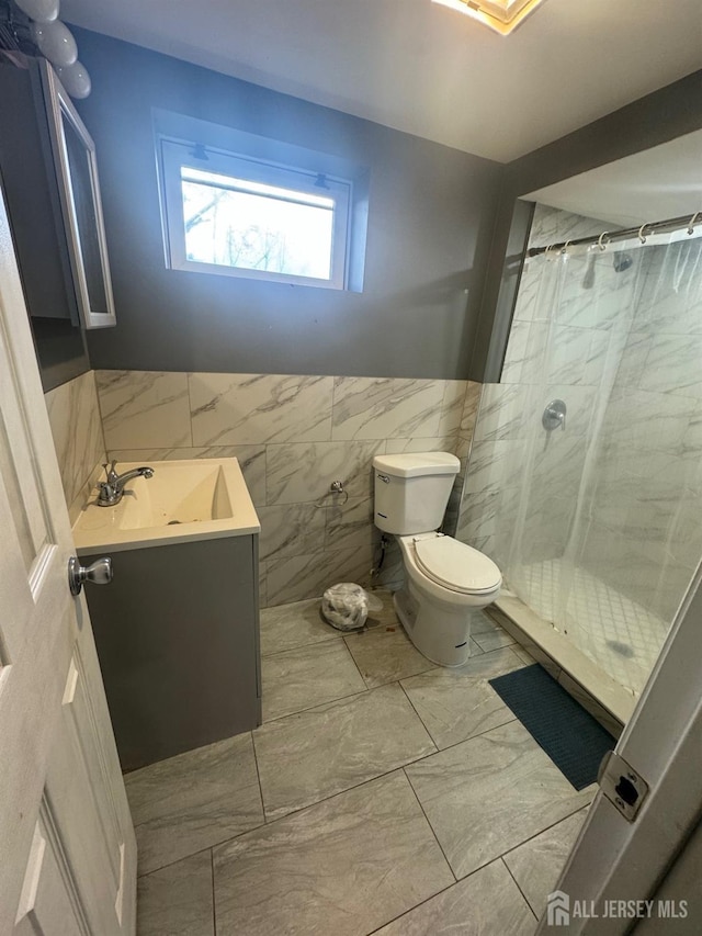 bathroom with a shower with curtain, vanity, toilet, and tile walls