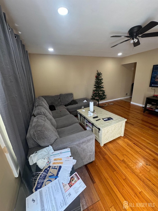 living room featuring wood-type flooring and ceiling fan