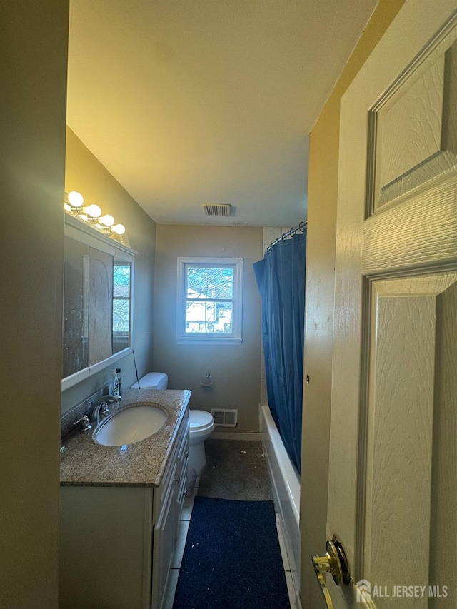 full bathroom with shower / tub combo with curtain, vanity, and toilet