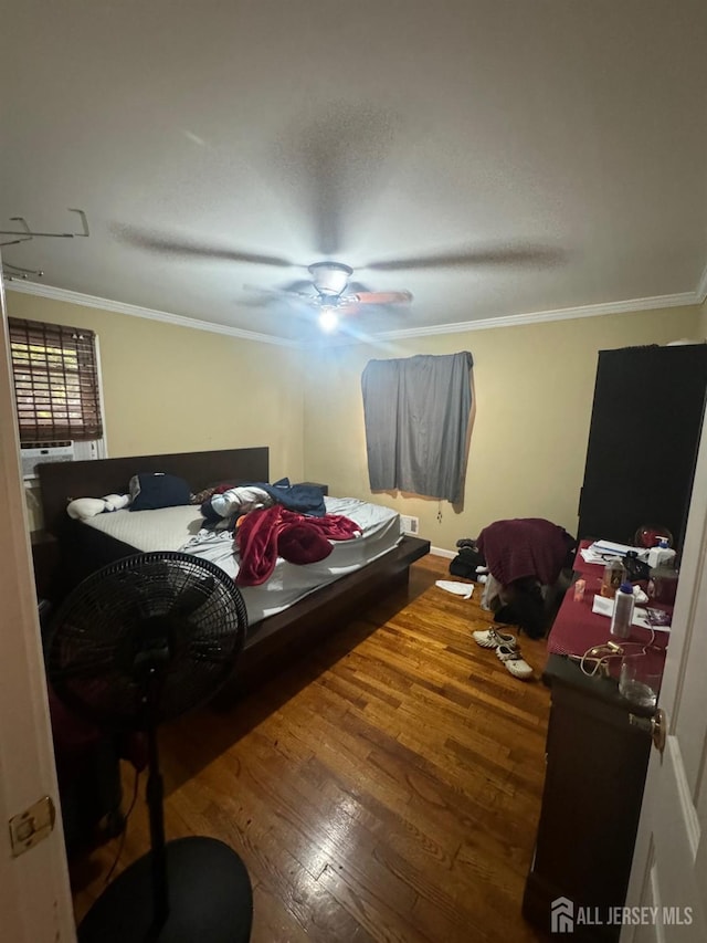 bedroom featuring crown molding, hardwood / wood-style floors, and ceiling fan