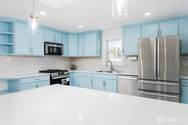 kitchen featuring sink, hanging light fixtures, stainless steel appliances, and blue cabinets