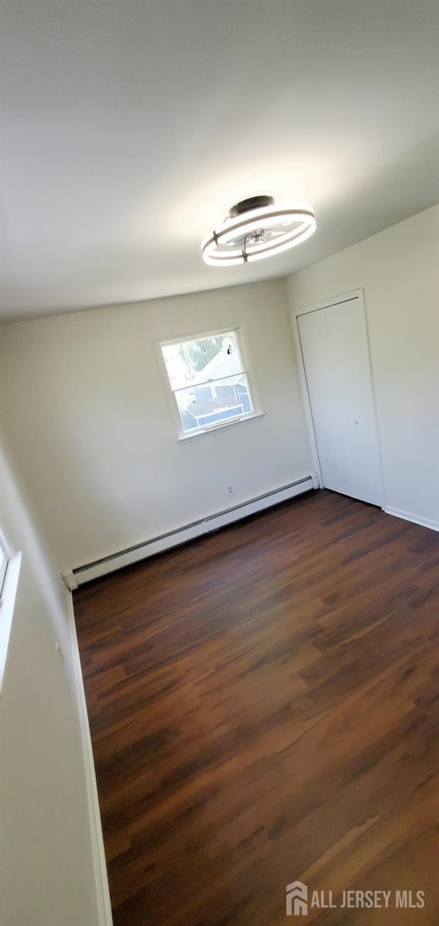 308 Codrington Pl, Bound Brook, NJ 08805 - unfurnished bedroom featuring a baseboard heating unit and dark wood finished floors