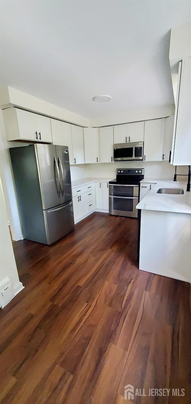 308 Codrington Pl, Bound Brook, NJ 08805 - kitchen featuring stainless steel appliances, light countertops, white cabinets, and dark wood-style floors