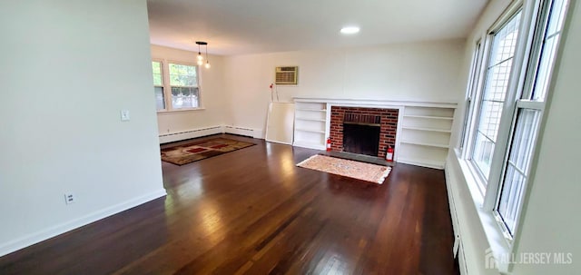308 Codrington Pl, Bound Brook, NJ 08805 - unfurnished living room featuring wood finished floors, baseboard heating, a brick fireplace, a wall mounted air conditioner, and recessed lighting