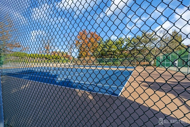 view of sport court featuring fence