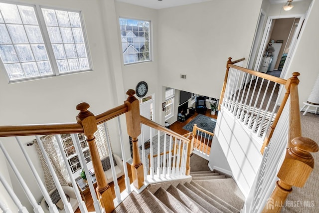 stairway with wood finished floors and visible vents