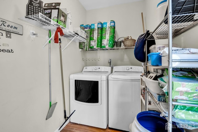 washroom featuring laundry area, washer and dryer, and wood finished floors