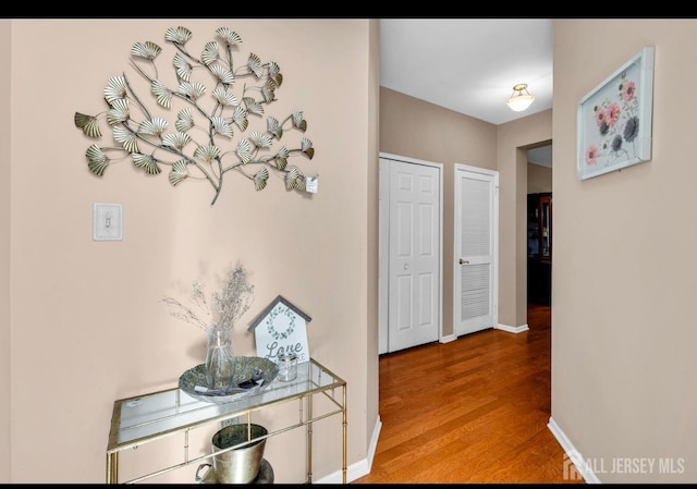 corridor featuring baseboards and wood finished floors