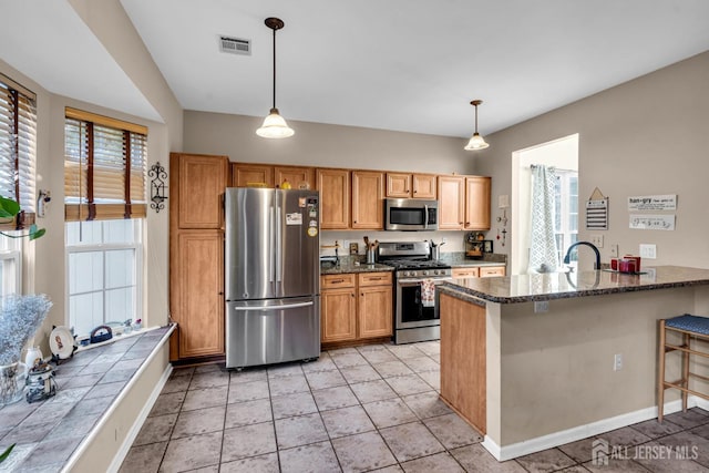 kitchen featuring appliances with stainless steel finishes, visible vents, hanging light fixtures, and a peninsula