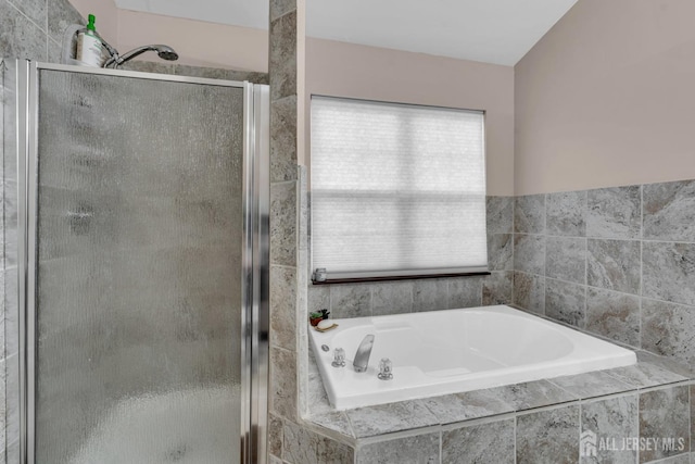 bathroom featuring a shower stall and a bath