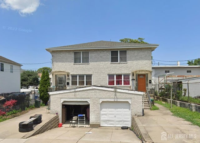 315 Harris St, Carteret, NJ 07008 - view of front of house featuring concrete driveway, a garage, brick siding, stairs, and fence