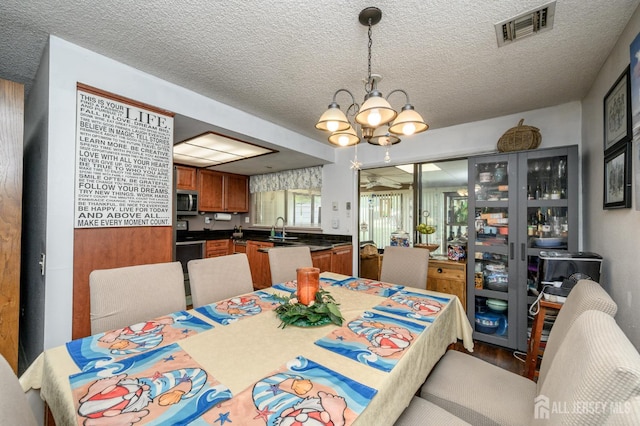 109-B Hemlock Plz, Monroe, NJ 08831 - dining room featuring a chandelier, a textured ceiling, and wood finished floors