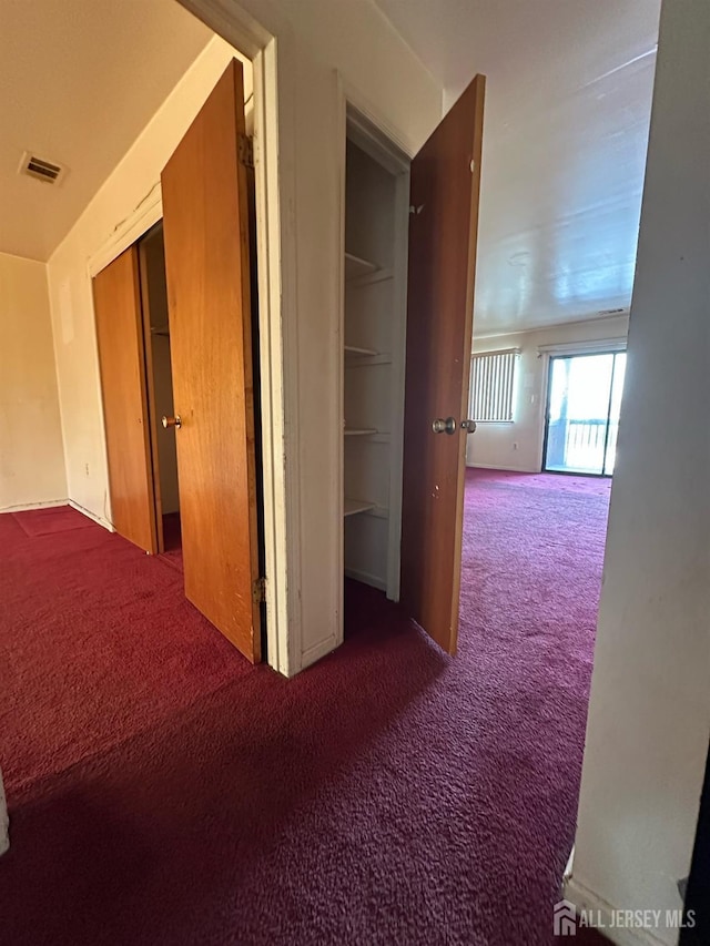 corridor featuring visible vents and carpet floors