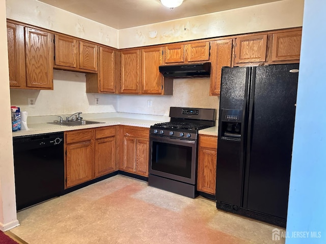 kitchen with under cabinet range hood, black appliances, light countertops, and a sink